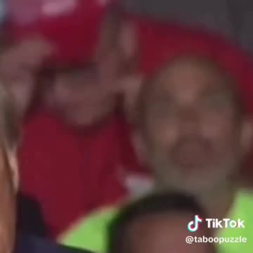Trump Michigan Rally - Man makes symbol to slash throat