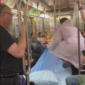 A man slept in a bed on the New York subway.