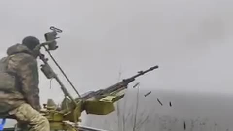 Ukrainian soldiers fire at a drone.