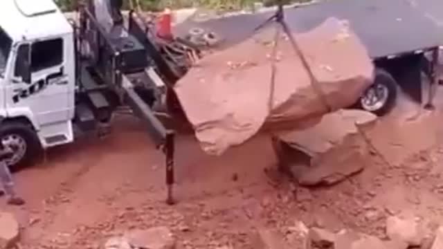 Funny people, this trucker is having a bad day as loading this rock is more difficult than it looks