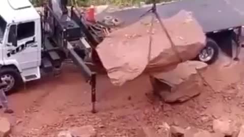 Funny people, this trucker is having a bad day as loading this rock is more difficult than it looks