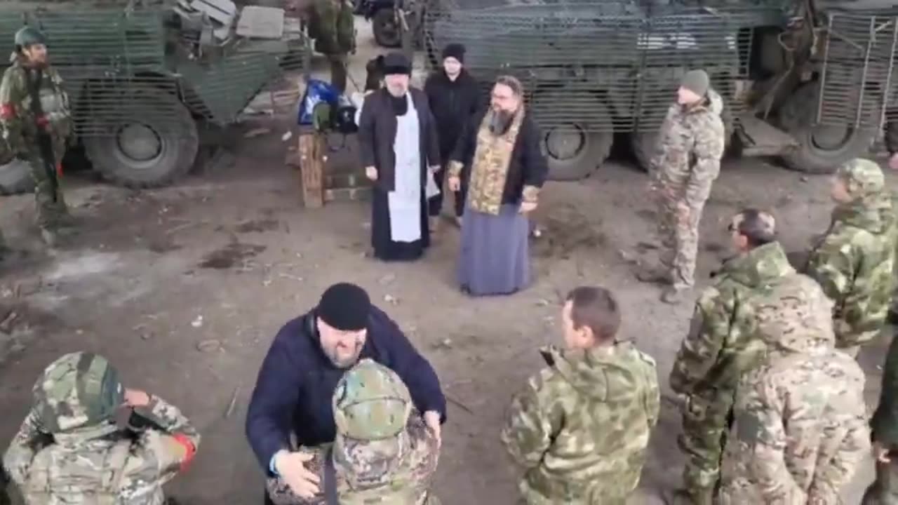 An Orthodox military priest hugs Russian soldiers before they go into battle.