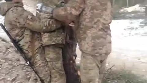 Ukrainian Soldiers taping one of there Brothers to a tree