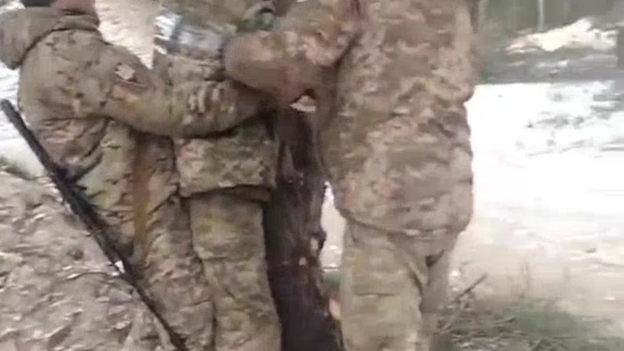 Ukrainian Soldiers taping one of there Brothers to a tree