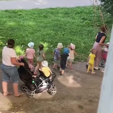 Children from a kindergarten in St. Petersburg walking while tied to a string