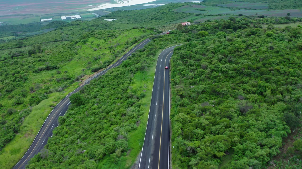 View of the road on the slopes of the mountain and surrounded by green forests