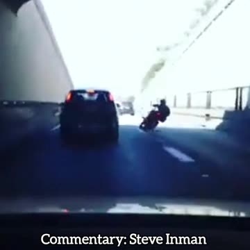 Kicks a car and crashes his bike.