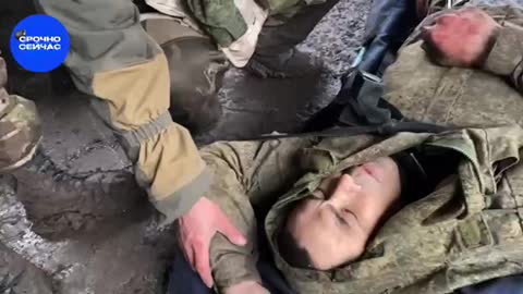 Russian soldiers pulling a injured comrade from the frontline to safety