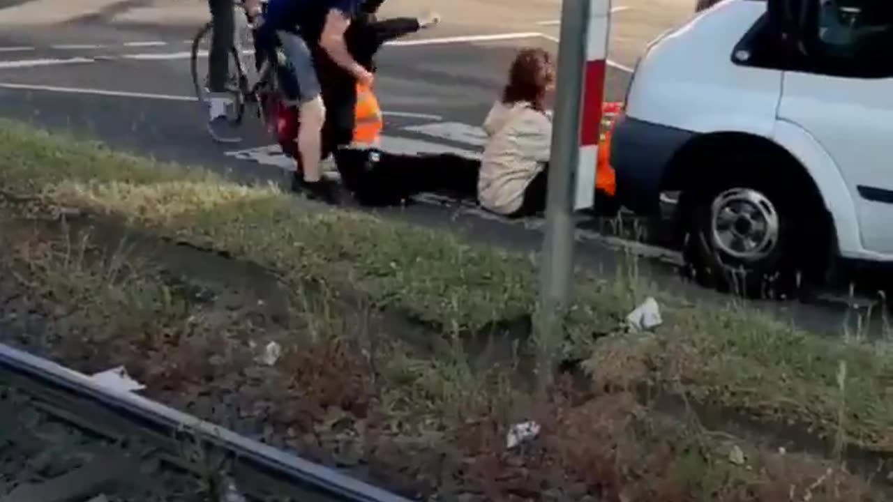 A business owner tries to deal with climate activists blocking a road in Cologne, Germany.