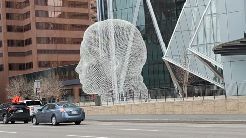 Walking past the Wonderland Sculpture at the Bow Tower Plaza. Calgary, Alberta.