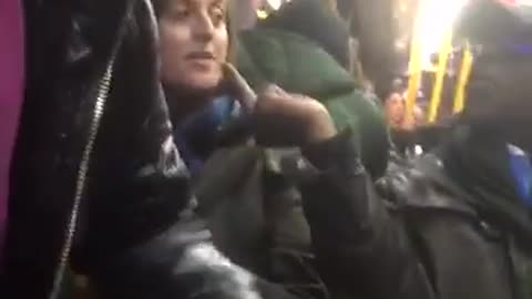 Black Migrant throws the middle finger to a woman from USA in the bus