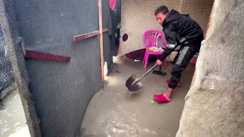 Families struggle to fix tents after rain causes flooding in Gaza