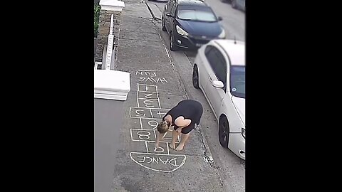 Lady draws hopscotch on sidewalk for pedestrians to have fun...