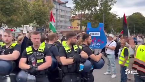 German woman, holding “rape isn’t resistance” sign ,protected by police from anti Israel protesters