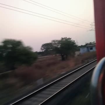 🚂🌾 Capturing the exhilarating sight of a fast-moving train through a village