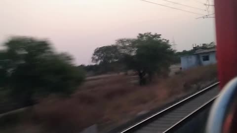 🚂🌾 Capturing the exhilarating sight of a fast-moving train through a village