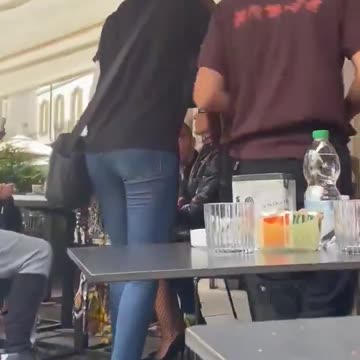 An African woman puts her hands around neck of a hard-working Italian