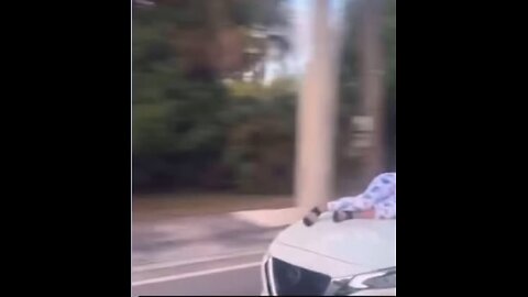 Woman clinging on to hood of her car