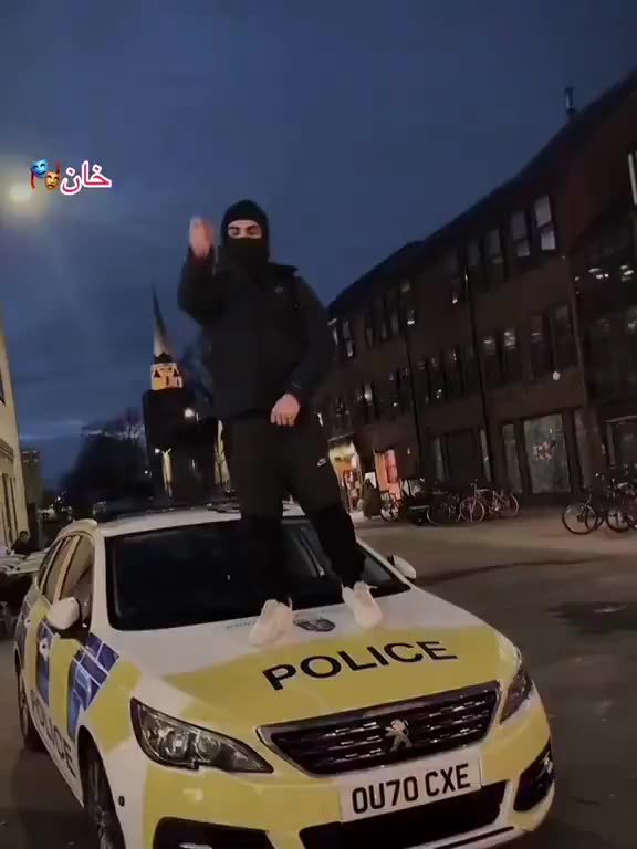 An illegal migrant stands on top of a British police car! Remigration now!