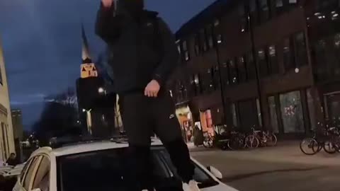 An illegal migrant stands on top of a British police car! Remigration now!