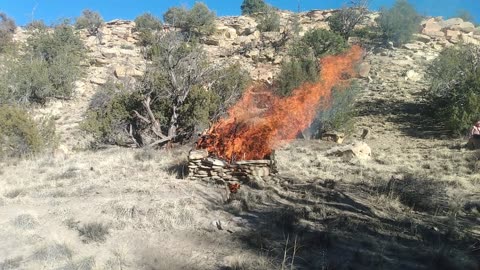 Fire Pyre Coal and wood burning in stone pit to melt down raw copper on site in Arizona