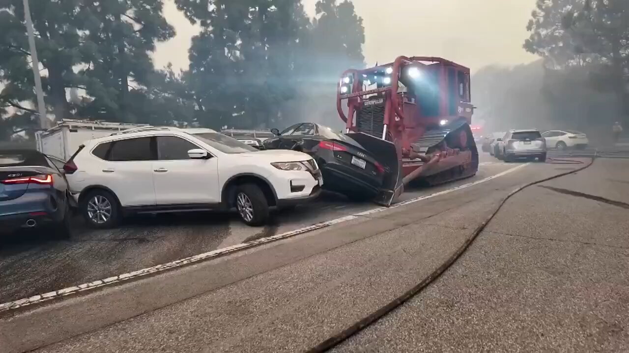 Bulldozer is being used to move abandoned cars out of the way - the Palisades Fire
