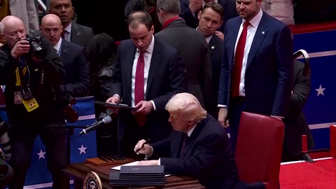 Trump signs first executive orders in front of a cheering crowd