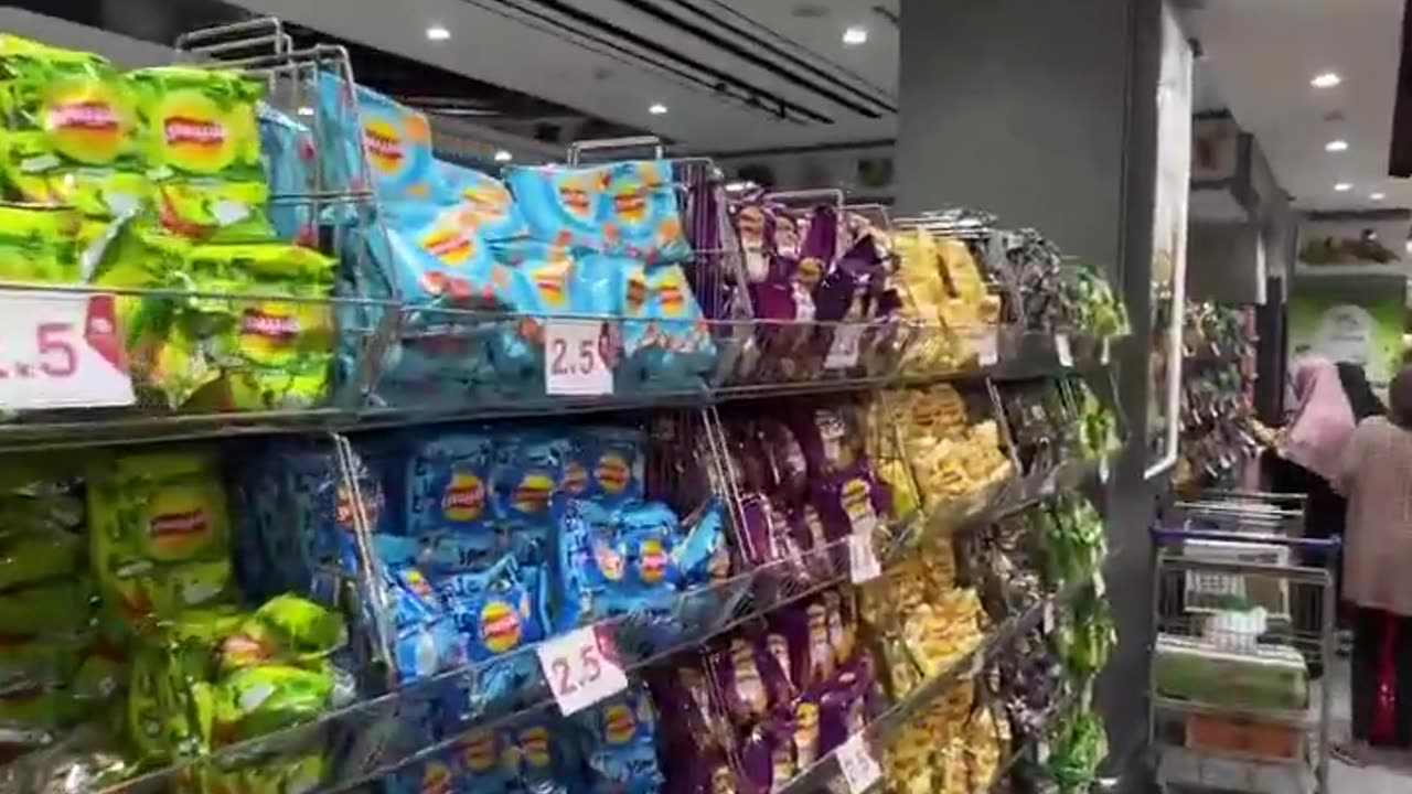 Palestinian man shows off abundance of fresh food in a Gaza supermarket