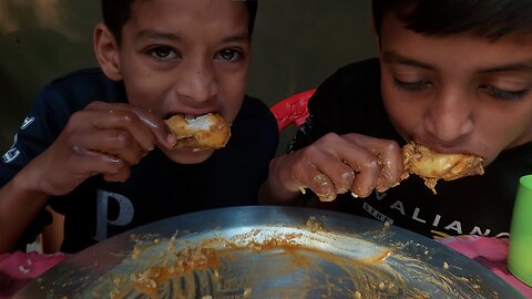 Two brothers are eating chicken & eggs curry, green vegetables with rice