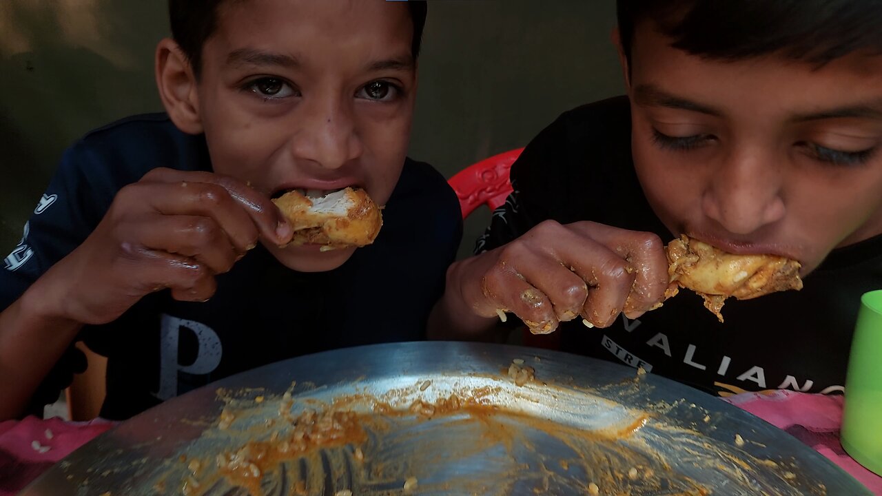 Two brothers are eating chicken & eggs curry, green vegetables with rice