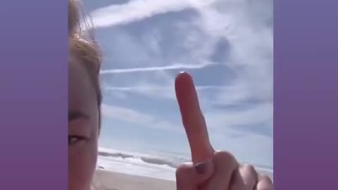 Nicole Shanahan, records a video showing geoengineering in the sky above her.