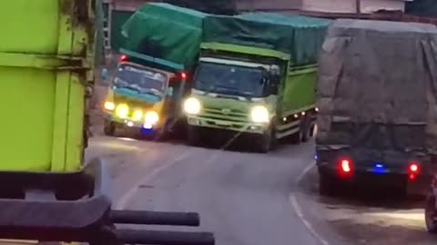 The tilted truck leans against the other truck, so that the truck doesn't roll over