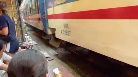 Train Passing a Café on the Iconic Train Street