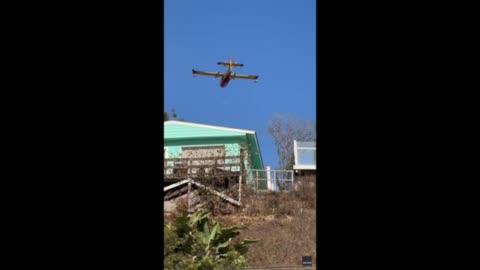 Firefighter plane scoops ocean water to battle Southern California wildfires