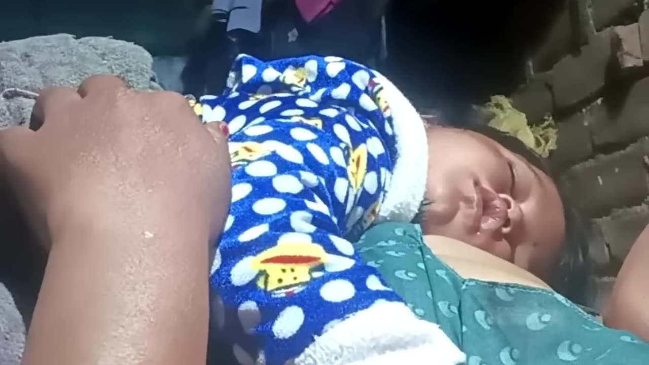 A mother is breastfeeding her baby at night