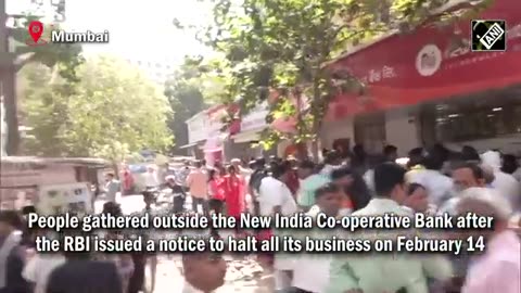 People gather outside New India Co-operative Bank after RBI issues notice to halt all business