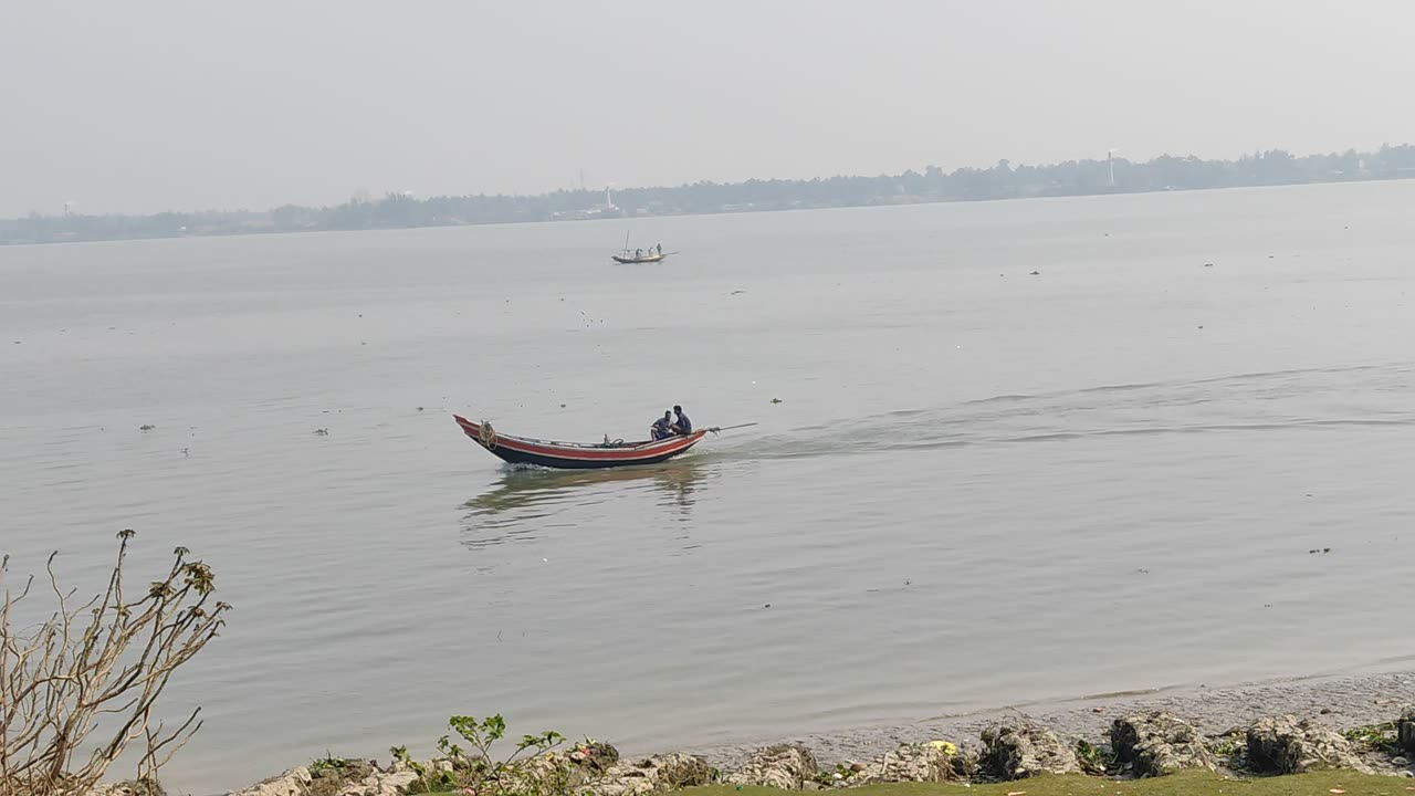 Two fisher man are going to catch fish by boat on the River Hooghly.
