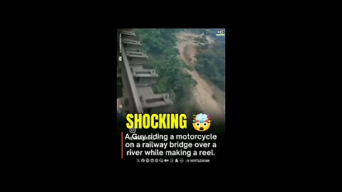 A Guy riding a motorcycle on a railway bridge over a river while making a reel