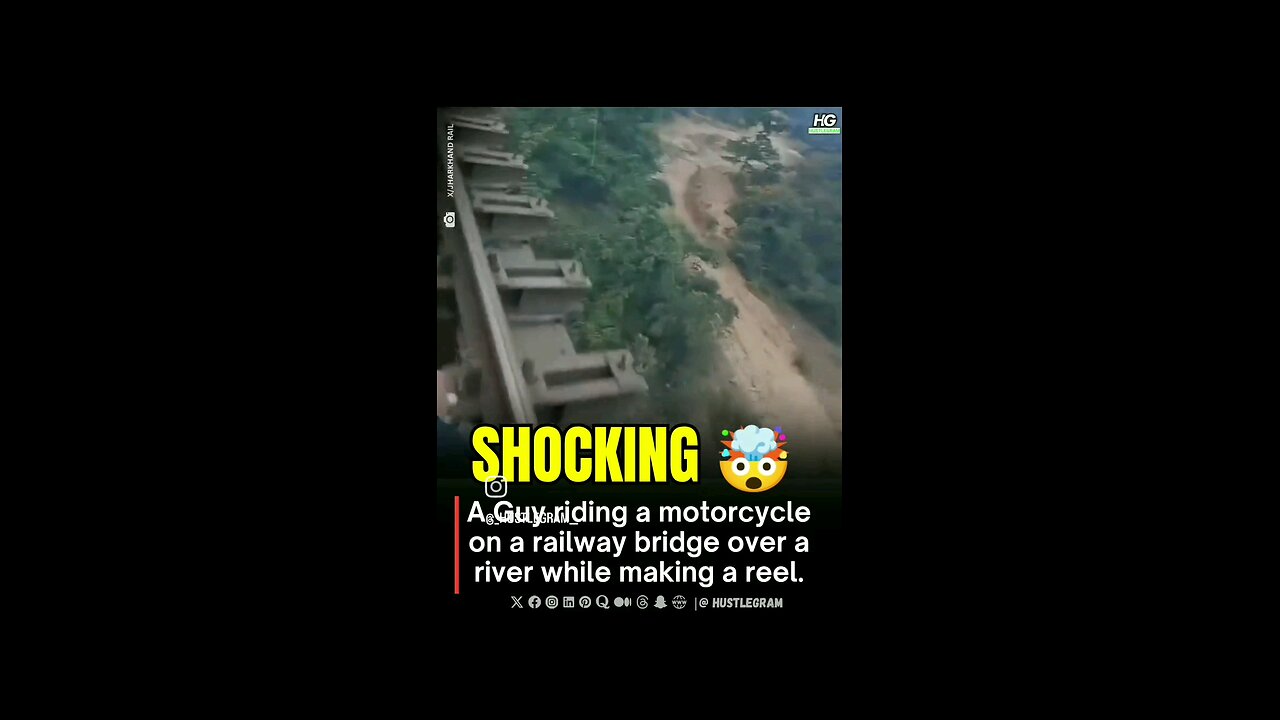 A Guy riding a motorcycle on a railway bridge over a river while making a reel