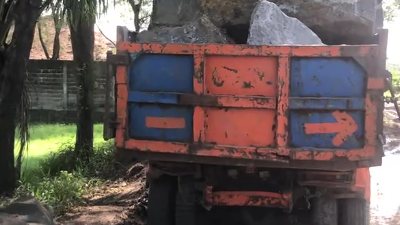 small truck loaded with large stones