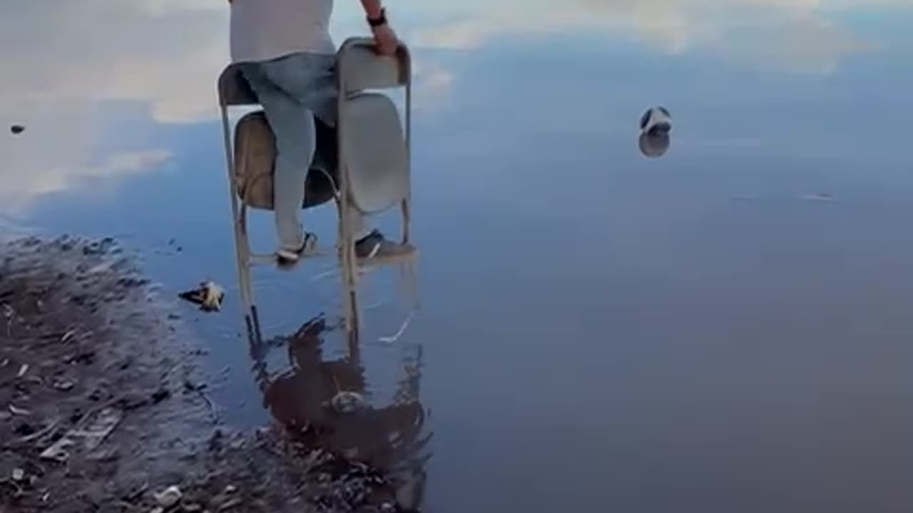 Man Uses Folding Chairs To Cross Water