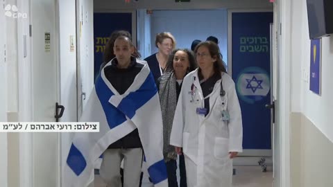 Released hostage Eli Sharabi arrives at Sheba Hospital wrapped in an Israeli flag.