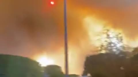 A rapidly advancing wildfire erupted in a Los Angeles suburb, destroying structures