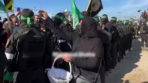 An elderly Palestinian woman sprinkles roses on the heads of the resistance fighters