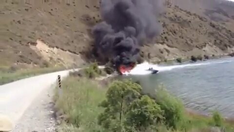 Two men putting out a fire using their speedboat