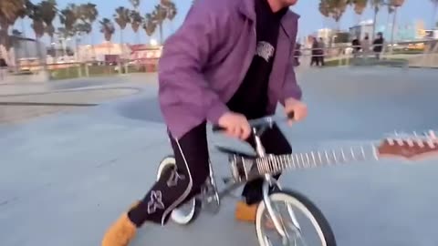 This boy built a guitar on his bicycle and kept playing it while riding the bicycle