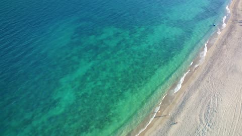Flying over a peaceful and sunny beach