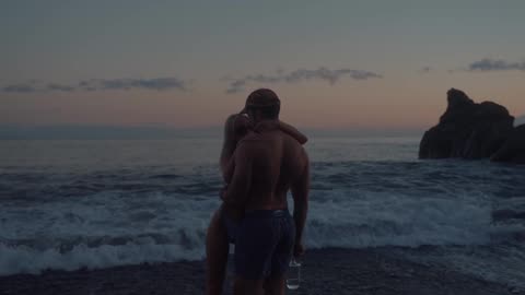 A couple walking and embracing by the shore
