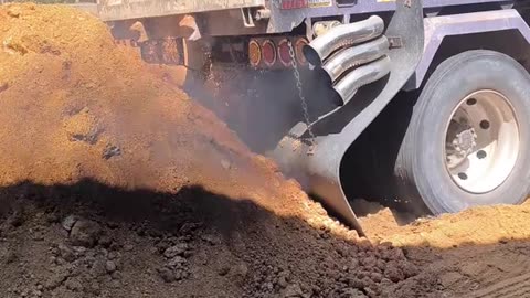 Dump truck slips tire while unloading cargo