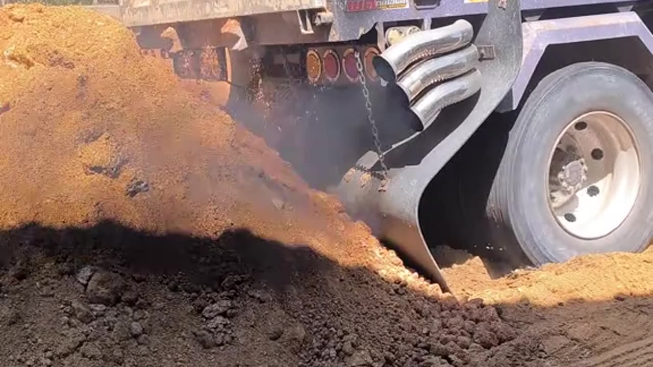 Dump truck slips tire while unloading cargo